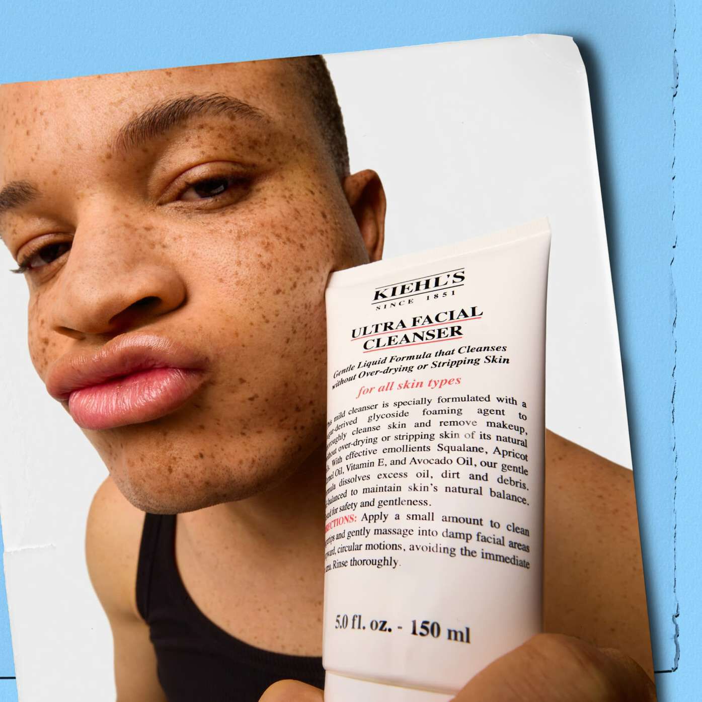 Model holding a tube of Kiehl's Ultra Facial Cleanser