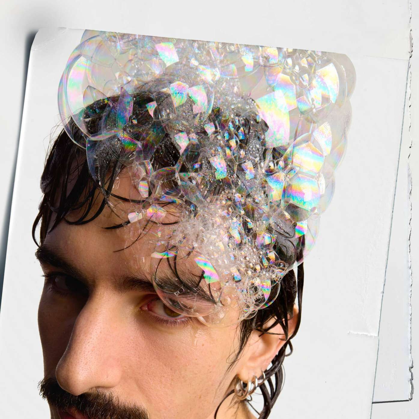 Model with bubbles on their head from Kiehl's Amino Acid Shampoo