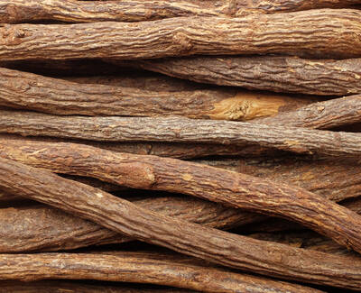 A close-up view of intertwined, textured sticks or roots, showing various shades of brown and a natural, rustic appearance.