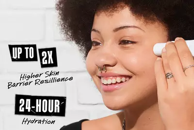 A smiling person with curly hair applies skincare product to their face, with text highlighting "Up to 2x Higher Skin Barrier Resilience" and "24-Hour Hydration" on the side.