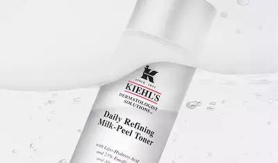 A bottle of Kiehl's Daily Refining Milk-Peel Toner, featuring a clean, minimalist design with a white background and water droplets.