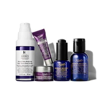 An assortment of skincare products from Kiehl's, including a Retinol serum, a multi-corrective cream, and several bottles of Midnight Recovery Concentrate and cleansing concentrate. All products are displayed in a well-lit arrangement against a white background.