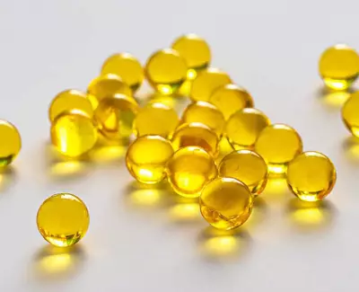 A scattered collection of translucent yellow gel-like spheres on a light surface.