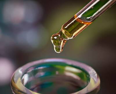 Close-up of a variety of roasted coffee beans, showing different shapes and shades of brown, densely packed together.