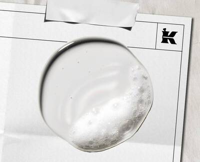 Close-up of green olives growing on a branch, surrounded by dark green leaves.