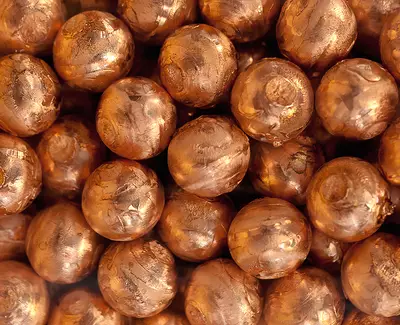A close-up view of numerous shiny, copper-colored spheres arranged closely together.