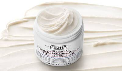 A jar of Kiehl's Ultra Facial Overnight Rehydrating Mask with a creamy texture, placed on a smooth, white background that resembles the product inside.