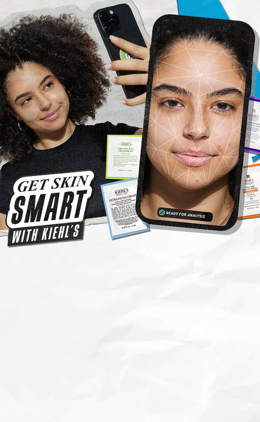 A young woman with curly hair is smiling while holding a smartphone. The background features skincare product cards and a digital display showing a facial analysis. The text reads "GET SKIN SMART WITH KIEHL'S."