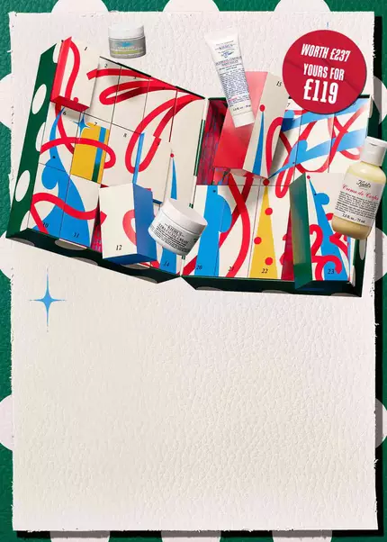 A festive mobile key visual for Kiehl's Holiday 2026 featuring an open advent calendar with colorful numbered drawers, holiday ribbons, and iconic skincare products including Ultra Facial Cream, Creme de Corps, and Ultimate Strength Hand Salve displayed against a festive green-and-white patterned background with blue sparkle accents.