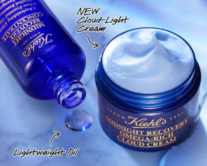 A jar of Kiehl's Midnight Recovery Omega-Rich Cloud Cream is shown with a small scoop taken out, beside a bottle of lightweight oil. The text promotes restoring younger-looking skin overnight and encourages customers to shop.